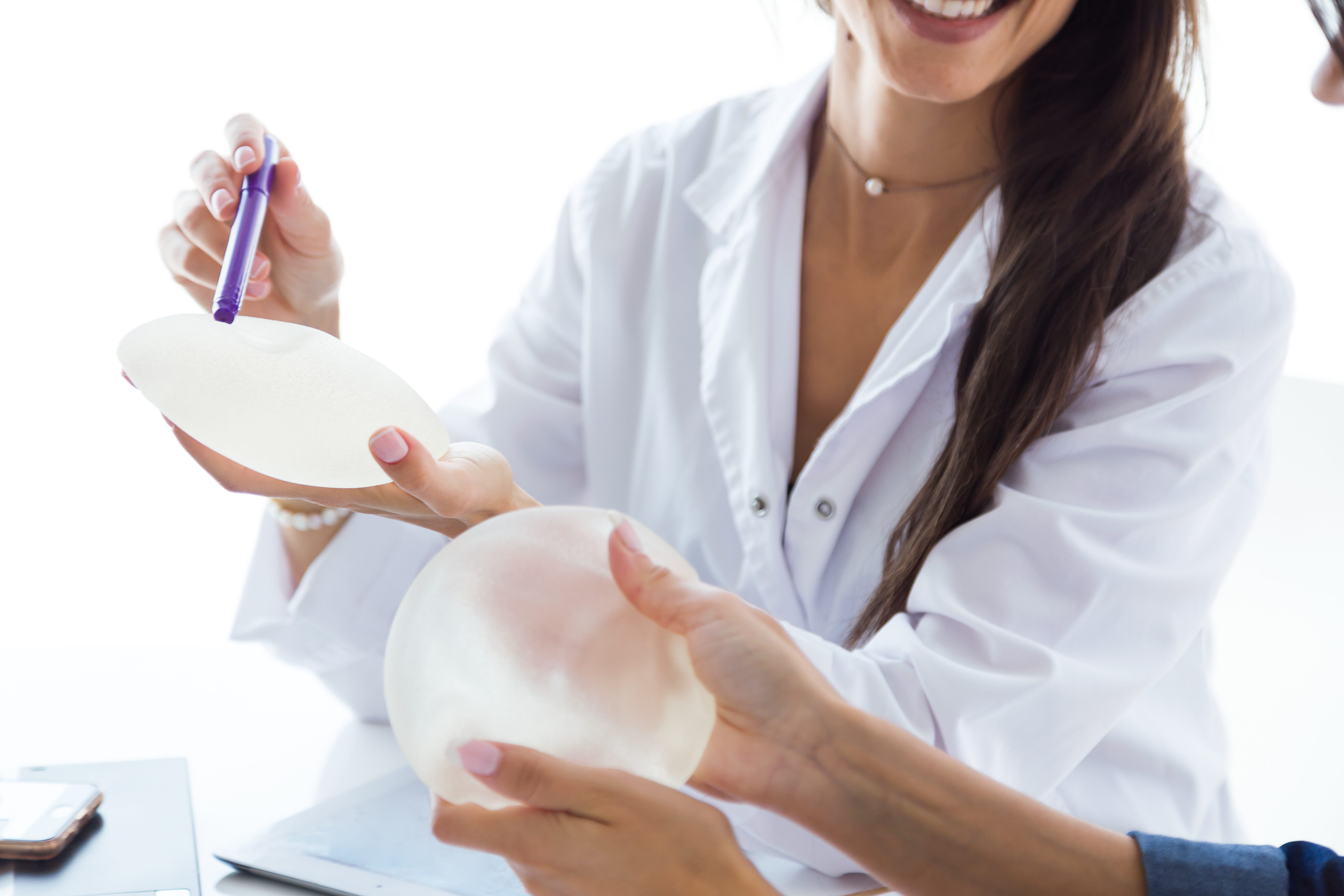 Doctor her patient choosing mammary prosthesis office